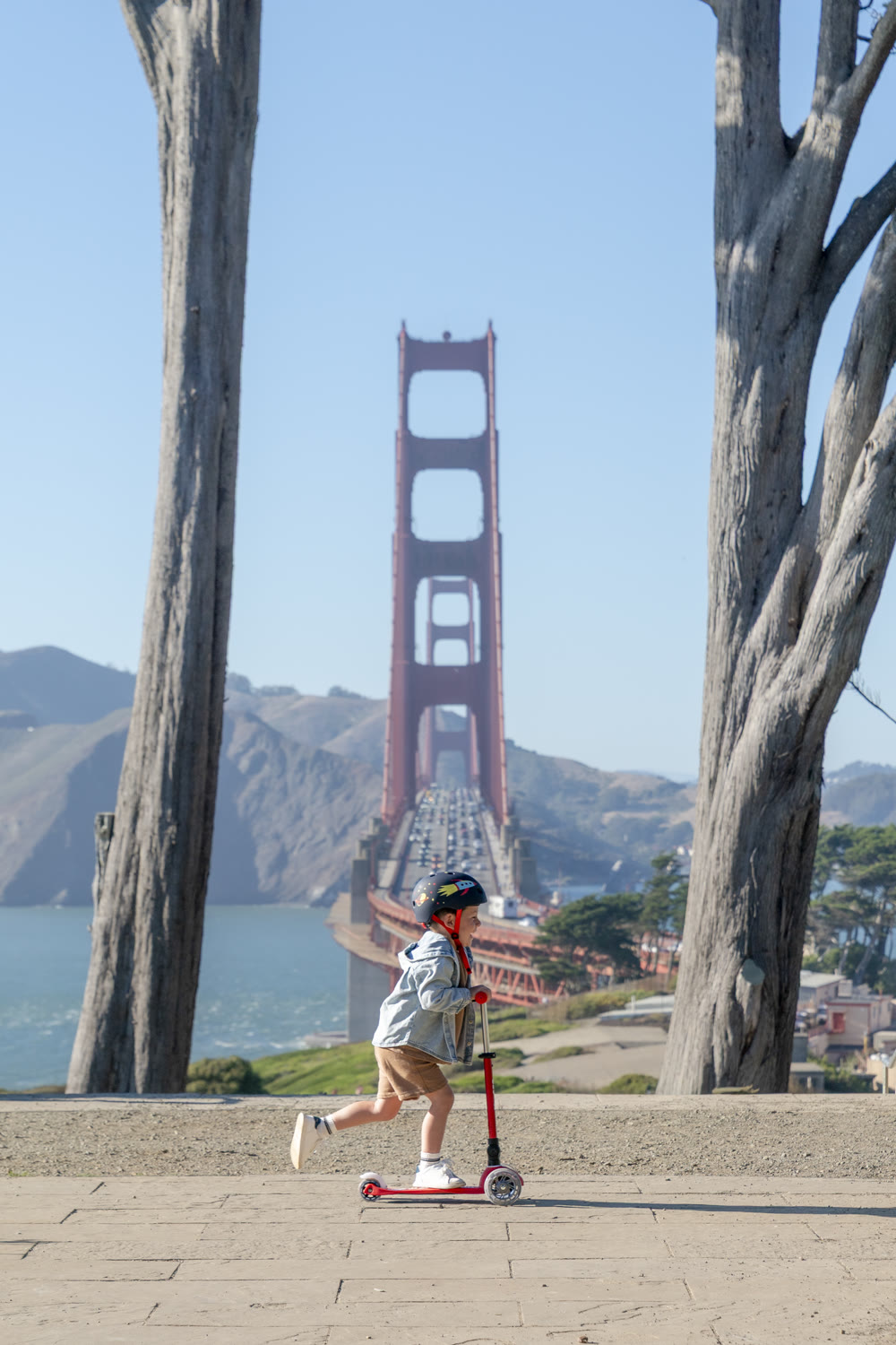 Kid riding a Micro Kickboard scooter near the Golden Gate Bridge