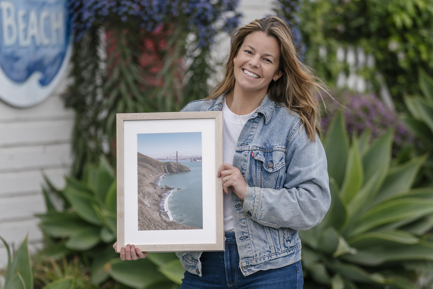 Colette Peri holding a framed Bay Area landscape print
