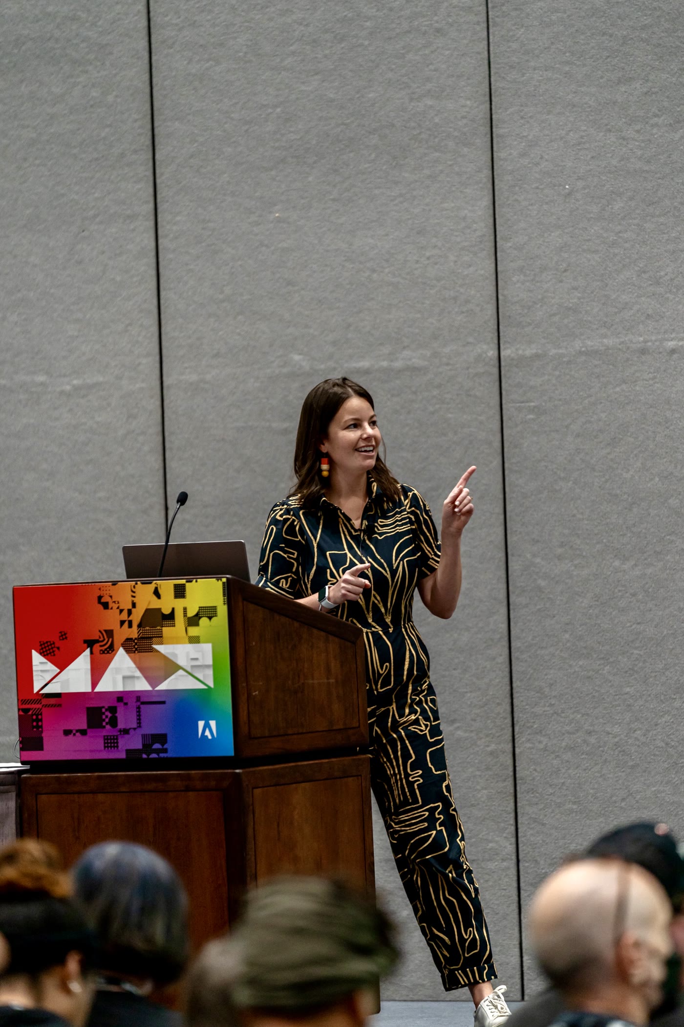 Colette Peri speaking at Adobe MAX, gesturing to the audience